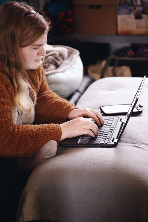 Estudiante adulta realizando formación a distancia con computadora portátil