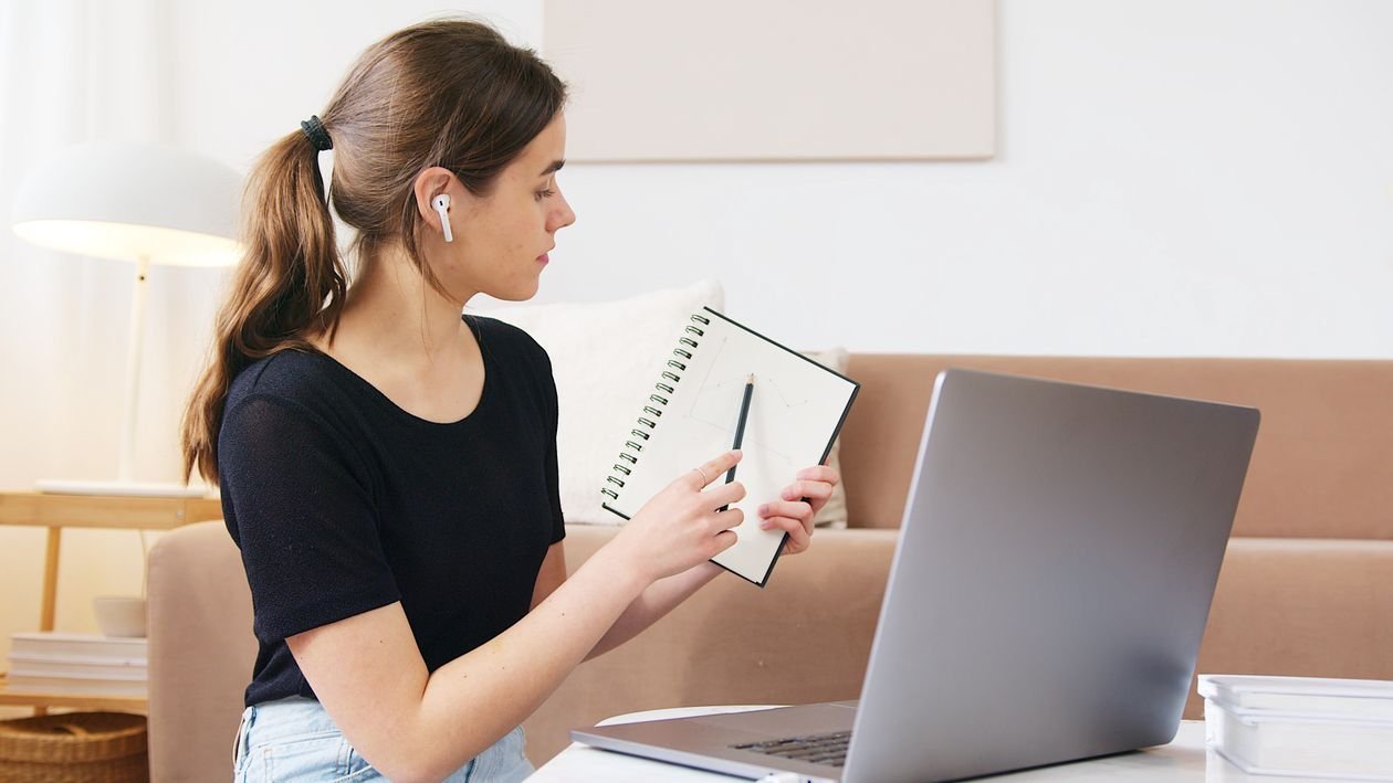 Mujer concentrada tomando un curso online en su laptop desde casa