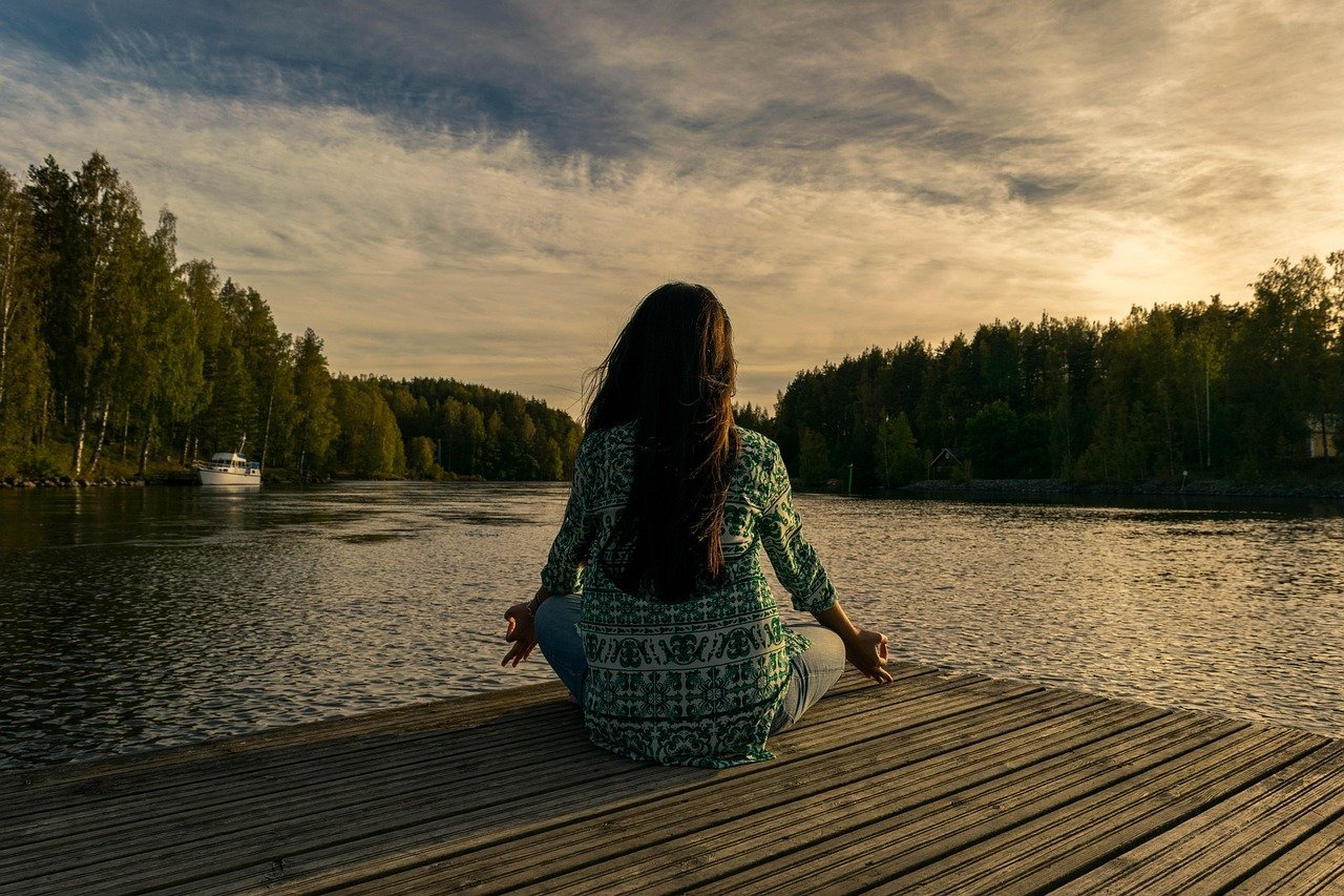 Persona meditando en calma al atardecer